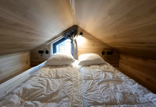 Schlafbereich mit zwei Einzelbetten im Tiny House in Gulperberg, Niederlande, Holz und Dachfenster.