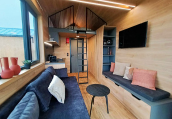 Gezellige en moderne tiny house lodge op Gulperberg met zithoek, keuken, tv en slaapzolder.