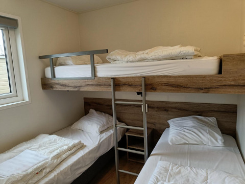 Chambre avec un lit superposé et deux lits simples au lodge Grandeur Panorama 5 à Gulperberg, Pays-Bas.