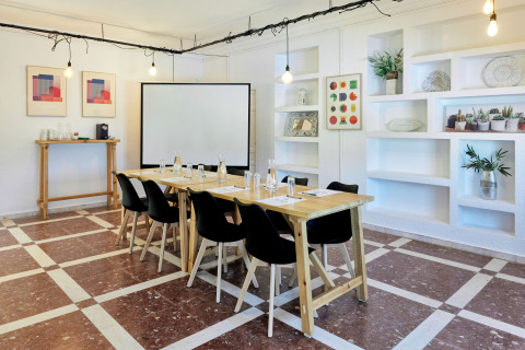 Vergaderruimte in TAIGA Conil vakantiepark, Andalusië, Spanje, met moderne houten tafels en decor.