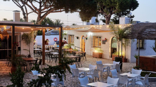 Zona exterior para comer en el parque vacacional TAIGA Conil en Andalucía, España, con luces y árboles.