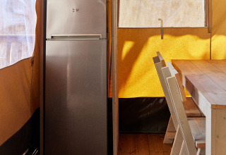 Küchenbereich im Glamping Safari Siroco Premium mit Kühlschrank, Mikrowelle und Esstisch in TAIGA Conil.