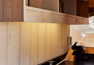 Coin cuisine moderne sous tente Safari Siroco Premium, TAIGA Conil, Espagne, avec finitions bois naturelles.