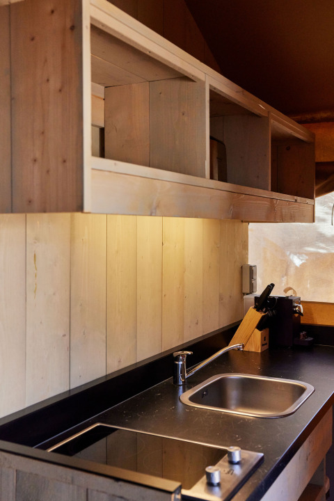 Moderne Küchenzeile im Glamping Safari Siroco Premium Zelt bei TAIGA Conil, Spanien, mit Holzakzenten.