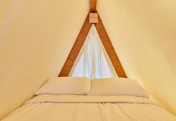 Vue intérieure de la zone de couchage dans une tente Glamping Tipi Almadraba à TAIGA Conil, Espagne