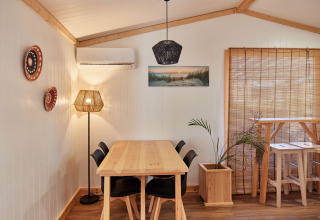 Comedor en Bungalow Premium Levante de TAIGA Conil, España, con muebles de madera y luz natural suave.