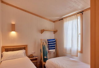Chambre lumineuse avec deux lits simples au Bungalow Premium Levante, TAIGA Conil, Espagne, décoration épurée.