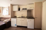Pequeña cocina moderna en Easy chalet, Eurocamping Vessem BV, Países Bajos, con sofá y electrodomésticos.
