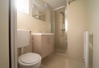 Et lyst og moderne badeværelse i Easy chalet på Eurocamping Vessem BV, Holland, med bruser og toilet.