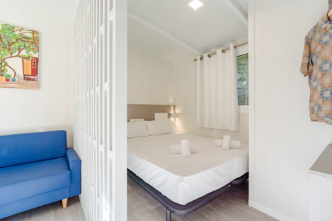 Camera luminosa e moderna presso Amos Studio al Camping Costa del Sol Glamping Village con letto matrimoniale e divano.