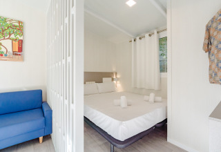 Camera luminosa e moderna presso Amos Studio al Camping Costa del Sol Glamping Village con letto matrimoniale e divano.