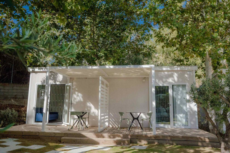 Amos Studio Lodge im Camping Costa del Sol Glamping Village in Spanien, von Bäumen umgeben fotografiert.