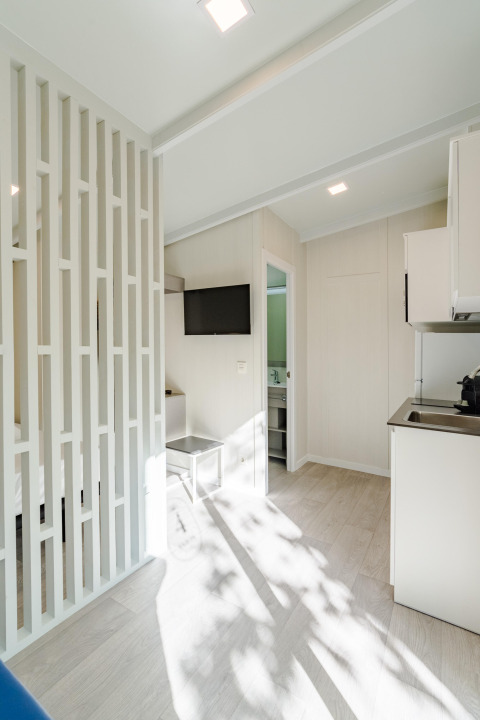 Moderna y luminosa lodge Amos Studio con cocina, TV y baño en Camping Costa del Sol Glamping Village, España.