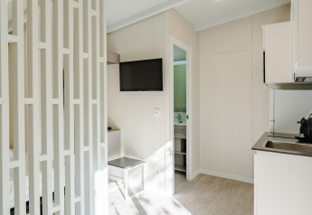 Moderne, lichte Amos Studio-lodge met keuken, tv en badkamer in Camping Costa del Sol Glamping Village, Spanje.