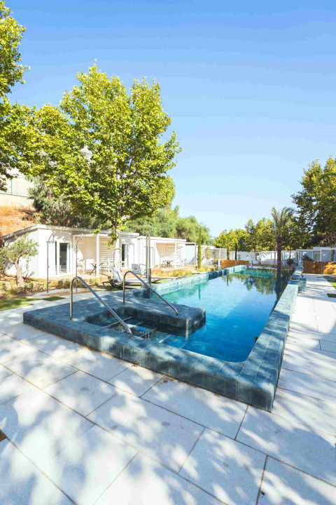 Piscine extérieure à Amos Studio, Camping Costa del Sol Glamping Village, entourée d’arbres et de chaises longues.