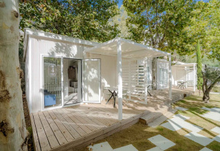 Lodge Amos Studio moderno con terrazza in legno e sedute esterne al Camping Costa del Sol Glamping Village, Spagna.