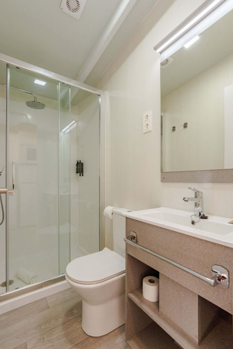 Salle de bain moderne avec douche, toilettes et lavabo à Amos Studio, Camping Costa del Sol Glamping Village.