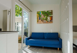 Salon moderne dans Amos Studio à Camping Costa del Sol Glamping Village, canapé bleu et tableau mural.