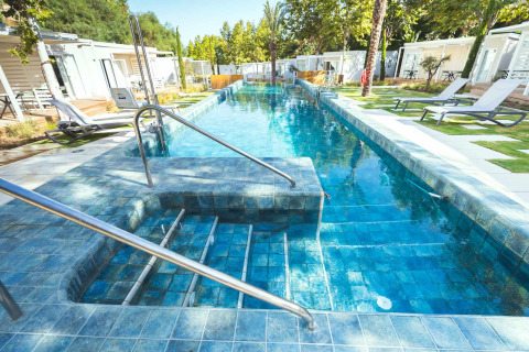 Piscina elegante con tumbonas en Amos Studio, Camping Costa del Sol Glamping Village en España.