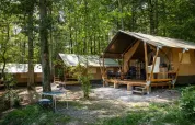 Tente safari dans la forêt au Camping Le Roptai en Belgique, avec terrasse et mobilier de jardin.