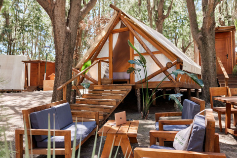 Tente safari Tamaral Tent à TAIGA Tarifa en Espagne, avec salons extérieurs et mobilier en bois sous les arbres.