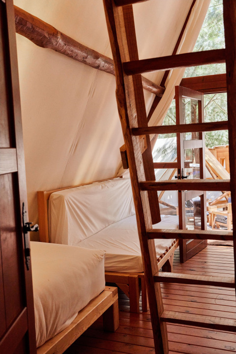 Interieur van de Sauceda-tent bij TAIGA Tarifa in Spanje, met houten vloer, ladder en veel licht.