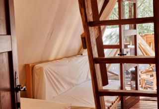 Interieur van de Sauceda-tent bij TAIGA Tarifa in Spanje, met houten vloer, ladder en veel licht.
