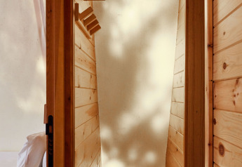 Interieur van Sauceda Tent bij TAIGA Tarifa, Spanje, met houten wanden en zacht natuurlijk licht.