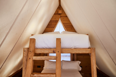 Knusse stapelbedden in de Algaida Tent safaritent bij TAIGA Tarifa in Spanje, met houten interieur.