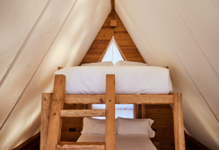 Camas literas acogedoras dentro de la tienda safari Algaida Tent en TAIGA Tarifa, España.