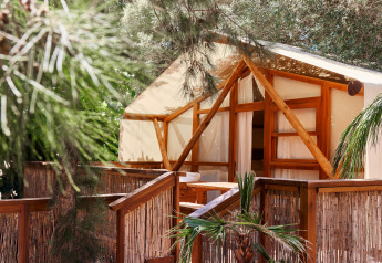 Tente de luxe Glamping La Cala à TAIGA Tarifa, Espagne, avec terrasse en bois entourée de verdure luxuriante.