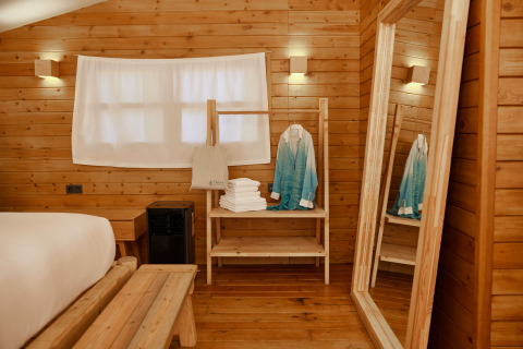 Interiør af Glamping Luxury Tent La Cala ved TAIGA Tarifa, Spanien, med trævægge og hyggelig stemning.