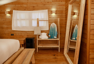 Interiør af Glamping Luxury Tent La Cala ved TAIGA Tarifa, Spanien, med trævægge og hyggelig stemning.