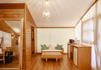 Innenraum des Glamping Luxury Tent La Cala bei TAIGA Tarifa, Spanien, mit hellem Holz und moderner Ausstattung.
