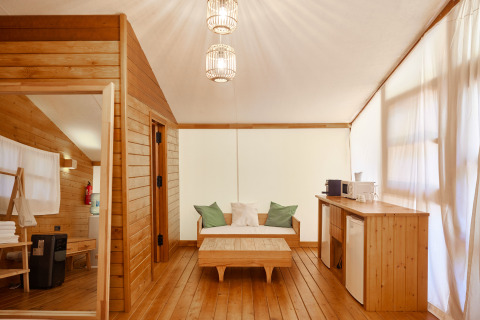 Interno del Glamping Luxury Tent La Cala a TAIGA Tarifa, Spagna, con legno chiaro e servizi moderni.