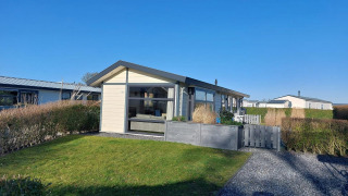 Chalet Velthorst à EuroParcs Parc du Soleil aux Pays-Bas, entouré de jardin et sous un ciel bleu clair.