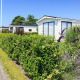 Hyggelige Berkel-hytter på EuroParcs Parc du Soleil i Holland, omgivet af grønne hække og blomster.