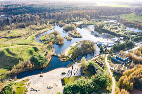 Luchtfoto van Netl Camping Kallumaan, een vakantiepark met water, groen en gebouwen in Flevoland.