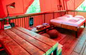 Agradable interior de la casa del árbol BoomBoom en Netl Camping Kallumaan, con mesa y cama de madera.