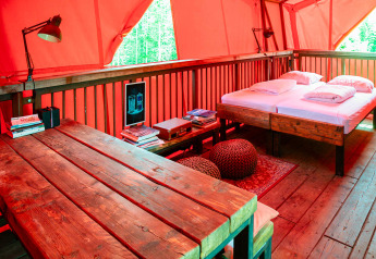 Intérieur chaleureux de la cabane BoomBoom à Netl Camping Kallumaan, table et lit en bois visibles.