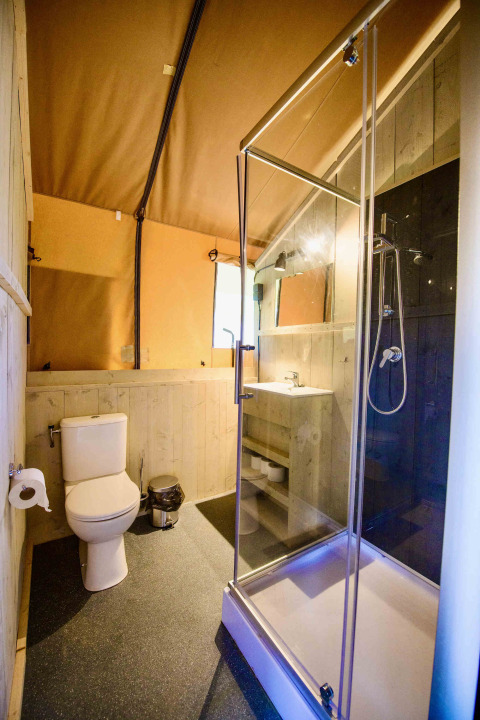Badkamer in safaritent Lodge + sanitary Leri - UFO bij Netl Camping Kallumaan, Nederland, met douche.