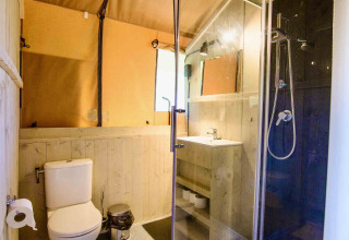 Badkamer in safaritent Lodge + sanitary Leri - UFO bij Netl Camping Kallumaan, Nederland, met douche.