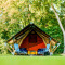Safaritent Lodge Mokki - UFO in een groen bos, twee blauwe stoelen voor de tent, ontspannen sfeer.