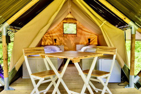 Binnenzicht van safaritent Lodge Mokki - UFO bij Netl Camping Kallumaan met stoelen en bedden.