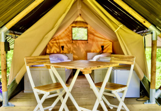 Binnenzicht van safaritent Lodge Mokki - UFO bij Netl Camping Kallumaan met stoelen en bedden.