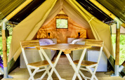 Interior view of Safari tent Lodge Mokki - UFO at Netl Camping Kallumaan with chairs and beds.
