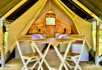 Vue intérieure de la tente safari Lodge Mokki - UFO au Netl Camping Kallumaan avec chaises et lits.