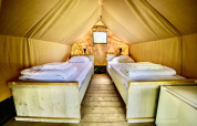Interior view of a safari tent Lodge Mokki - UFO with two single beds at Netl Camping Kallumaan, Netherlands.