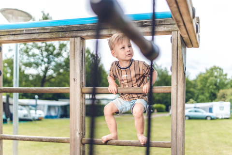 Jongen speelt op een speeltuig in Veluwepark de Bosgraaf, vakantiepark in Gelderland, Nederland.
