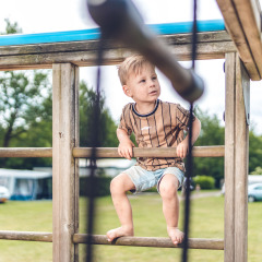 Niño jugando en un parque infantil en Veluwepark de Bosgraaf, parque vacacional en Gelderland, Países Bajos.